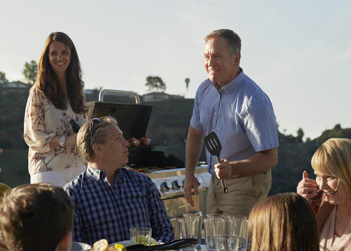 Man and wife with hearing aids at family barbecue 
