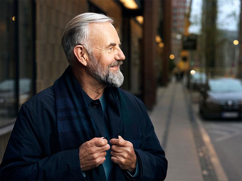 Smiling man in the street, wearing his Beltone hearing aids