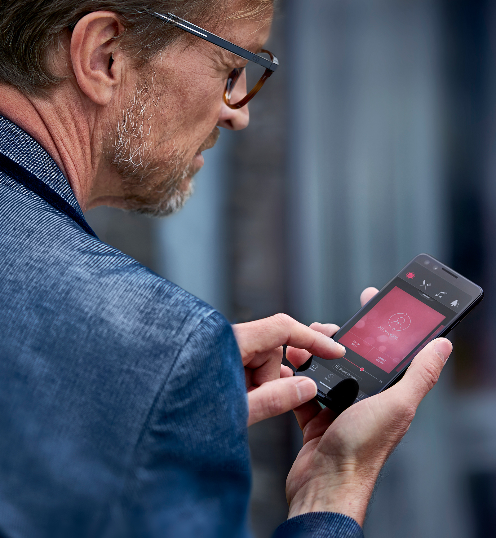Woman wearing ReSound LiNX3D hearing aids and streaming sound to them through her Android phone.