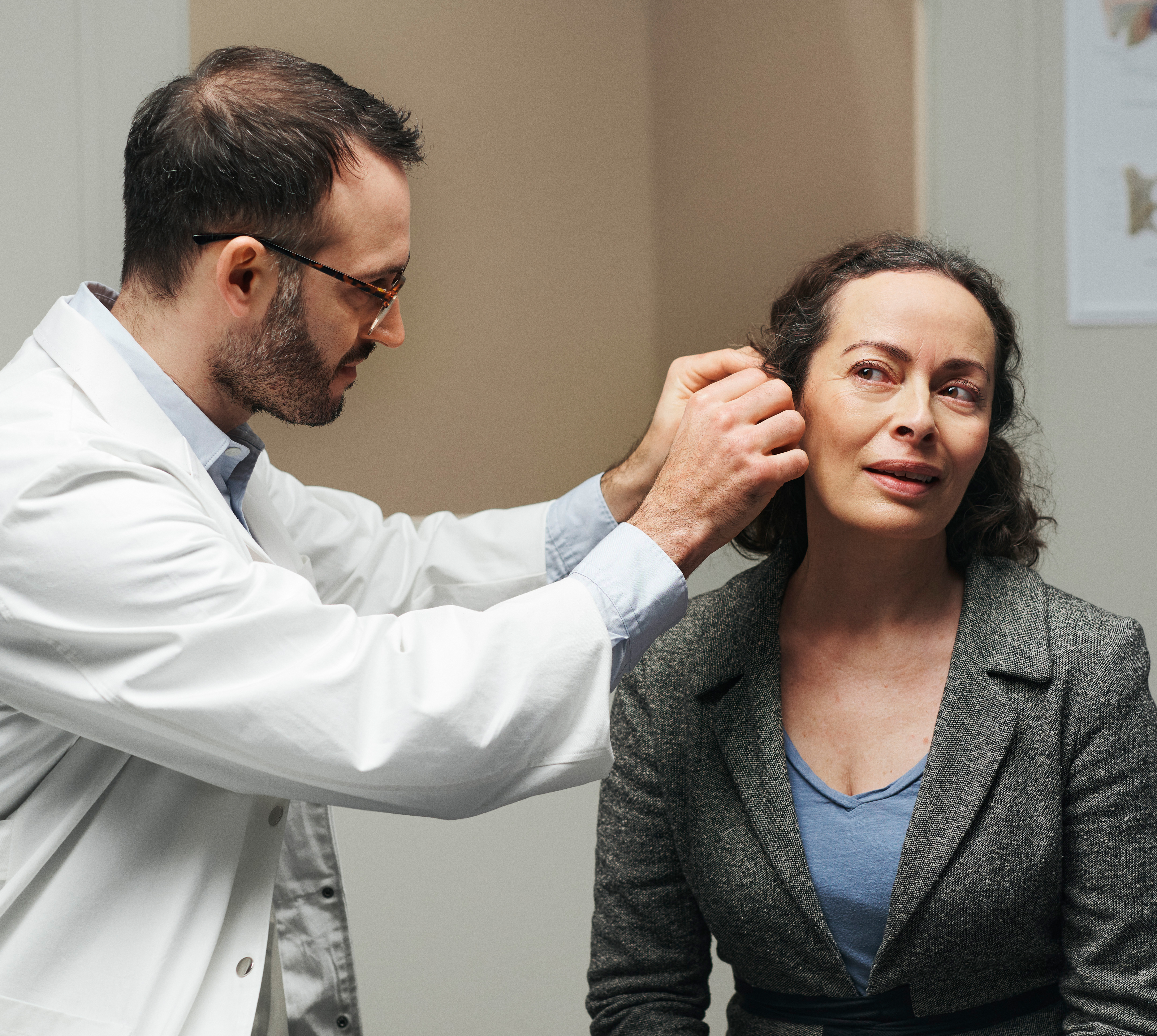 Hearing care professional fitting a user with a custom device.