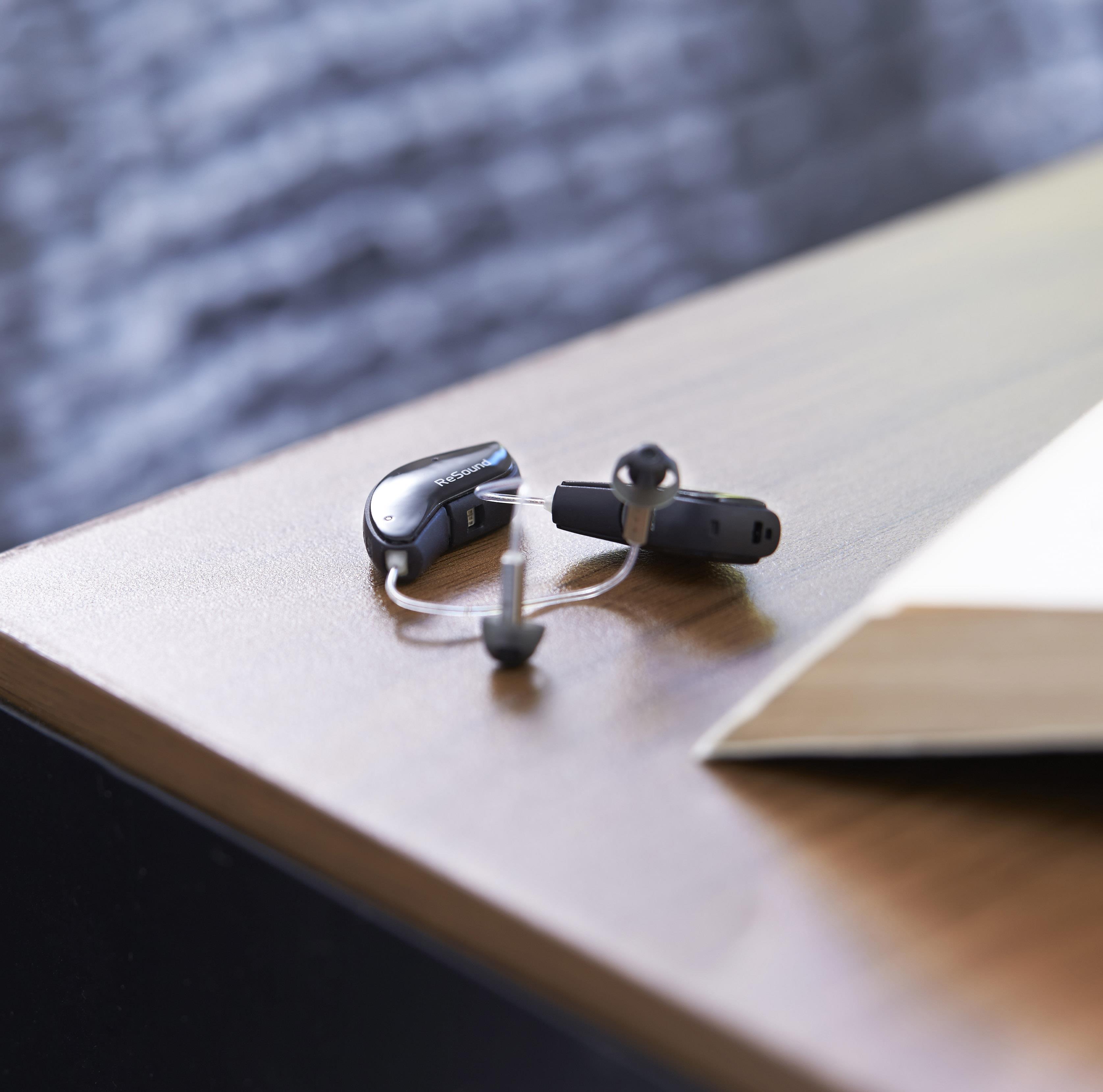 Pair of ReSound  hearing aids on a table.