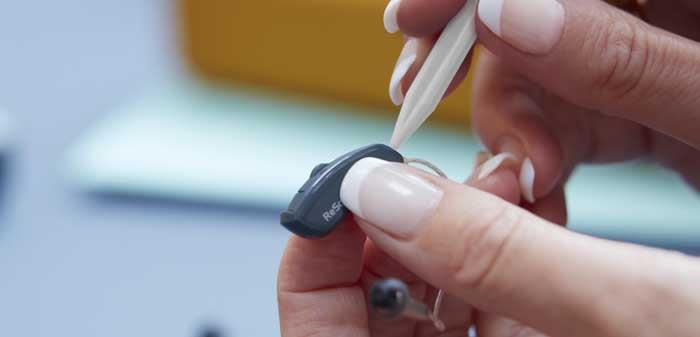 Woman repairing a ReSound hearing aid.