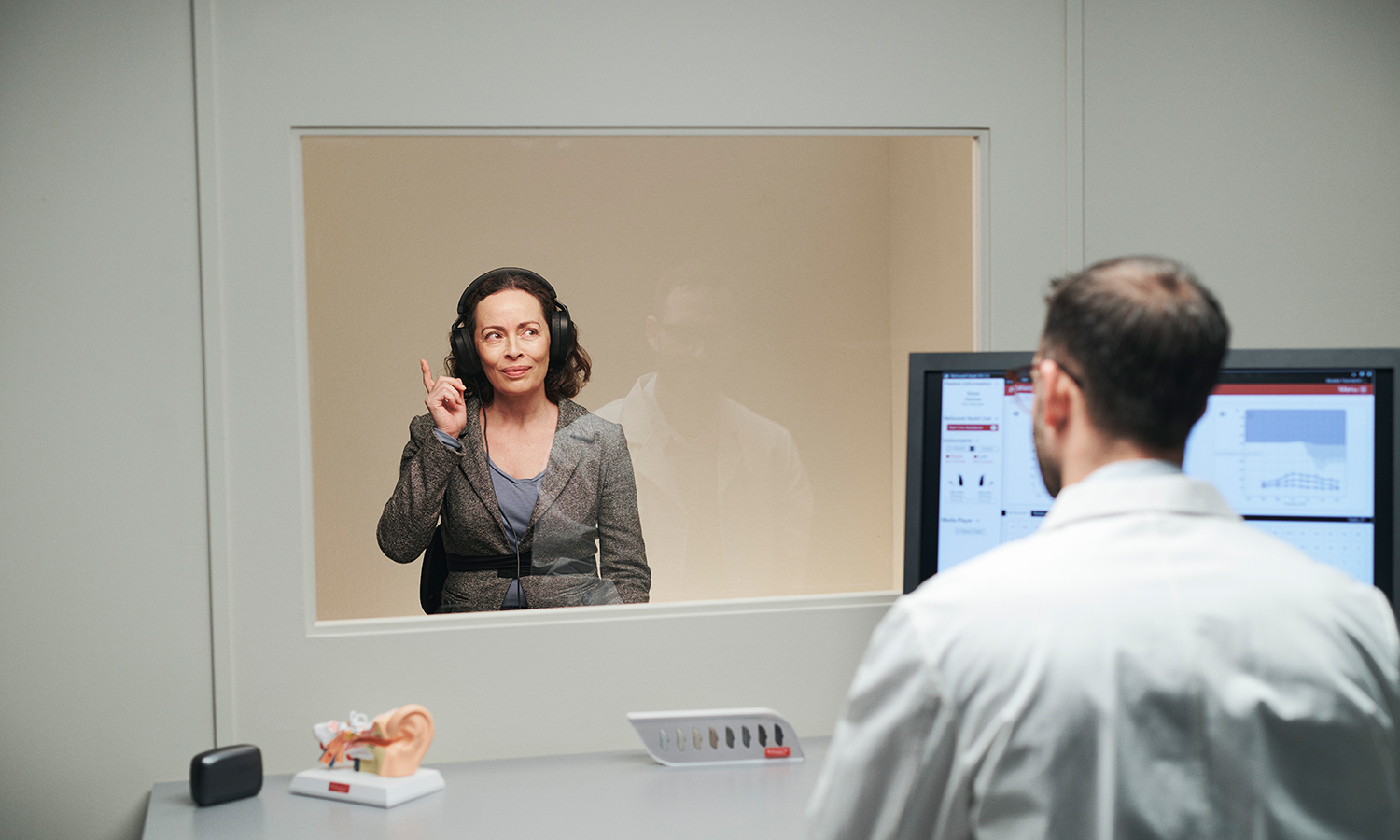 Hearing care professional testing a patient's hearing.