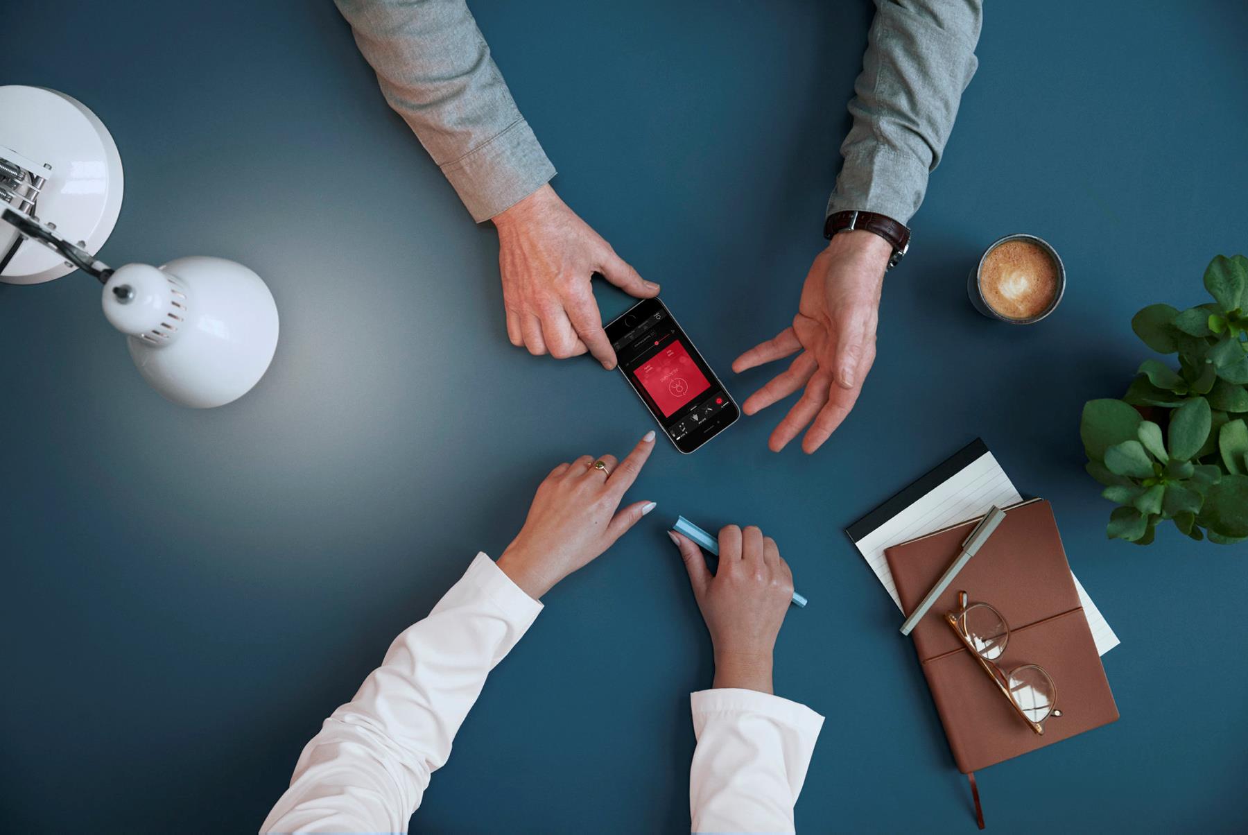 Business meeting with phone on table | Resound hearing aids