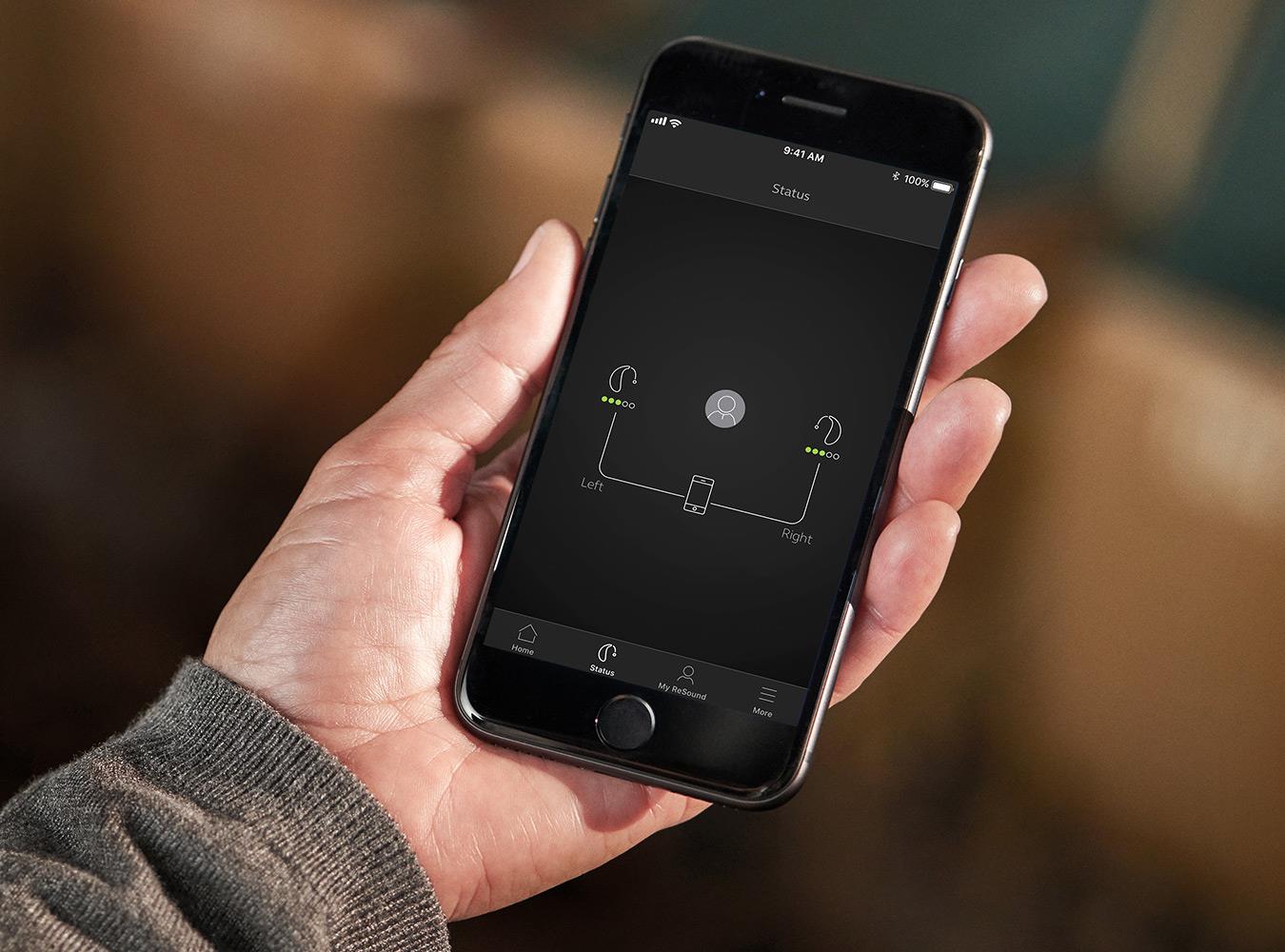 Mand, der tjekker batteriforbruget i sine ReSound LiNX Quattro via sin telefon. 